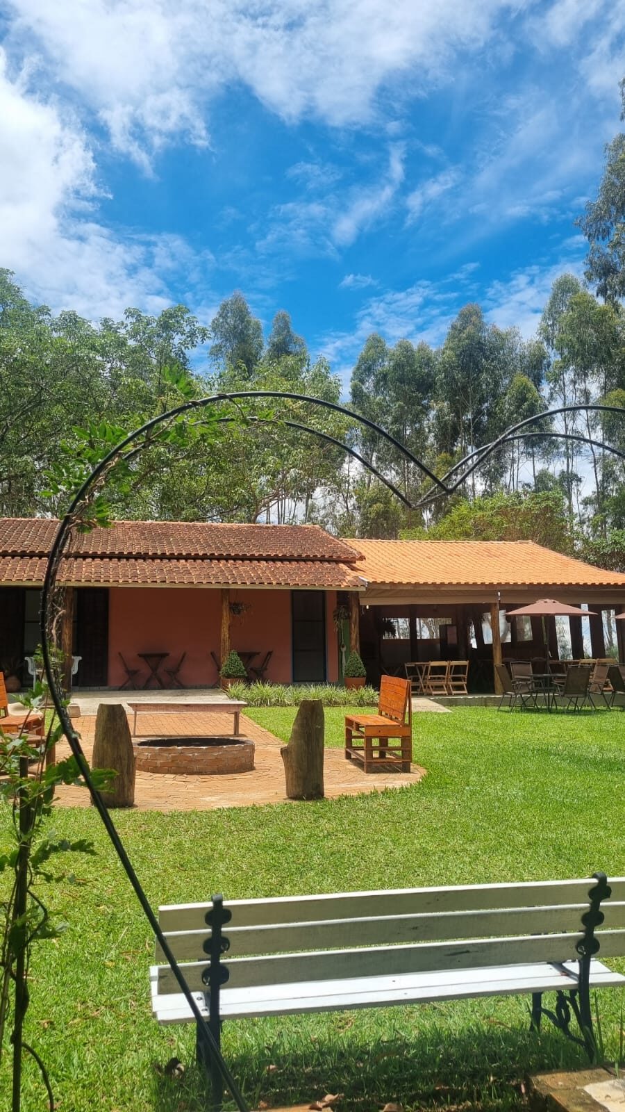 Fachada do Rancho Vovó Lulu com fogueira, bancos e céu azul